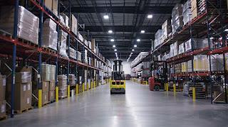 A forklift operating in a busy warehouse captured with a wide-angle lens. A forklift operating in a busy warehouse captured with a wide-angle lens.