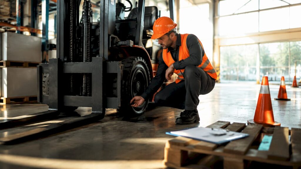 Forklift operator inspecting forklift for safety