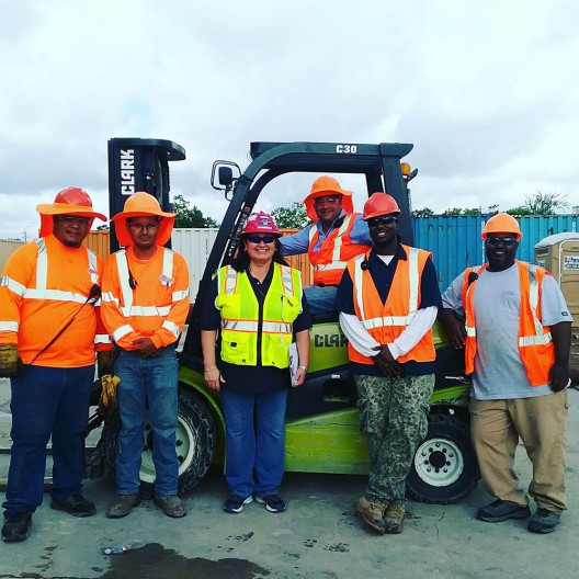 five men and a woman posing with forklift